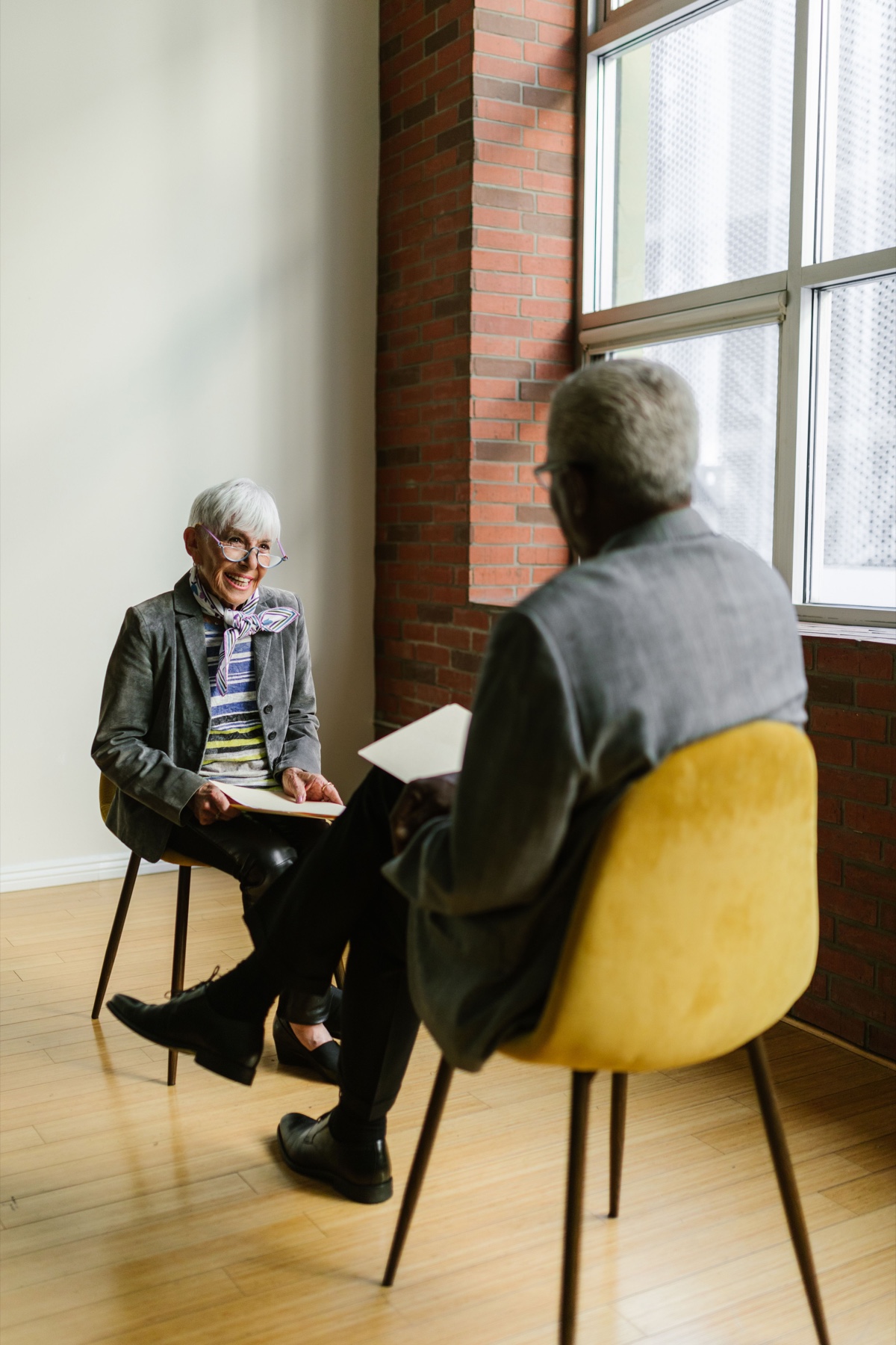 Two older adults seated together in a one-on-one conversation